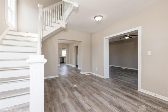 foyer entrance featuring stairway, wood finished floors, and baseboards