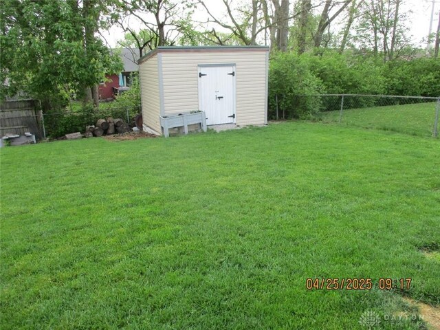 view of yard with a storage unit, fence, and an outdoor structure
