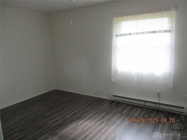 unfurnished room featuring wood finished floors, a healthy amount of sunlight, baseboards, and a baseboard radiator