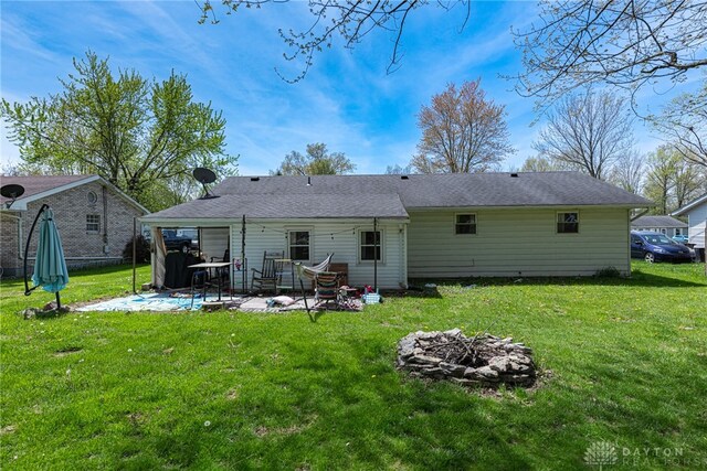 7351 Willow Dr, Blanchester, OH 45107 - rear view of property with a patio, a fire pit, and a lawn