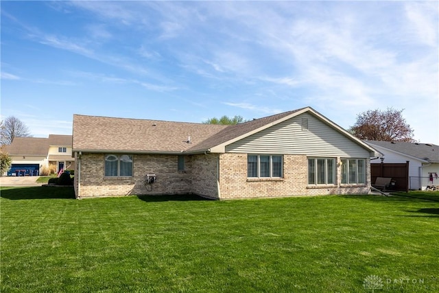 1823 Park Ave, Piqua, OH 45356 - back of property featuring roof with shingles, a yard, and brick siding