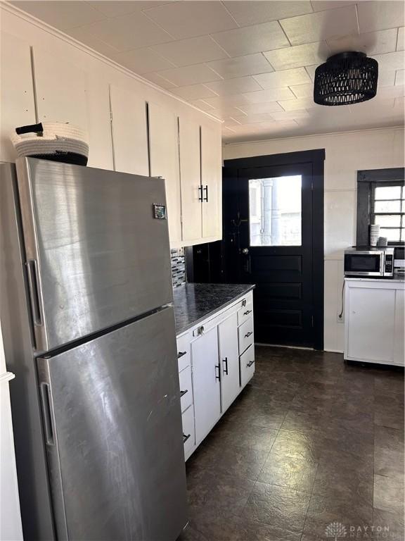 32 W 3rd St, West Alexandria, OH 45381 - kitchen featuring appliances with stainless steel finishes, white cabinets, dark countertops, and dark floors