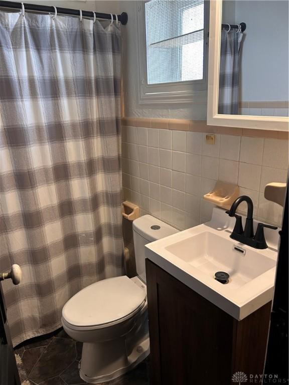 32 W 3rd St, West Alexandria, OH 45381 - full bathroom with tile walls, vanity, toilet, a shower with shower curtain, and backsplash