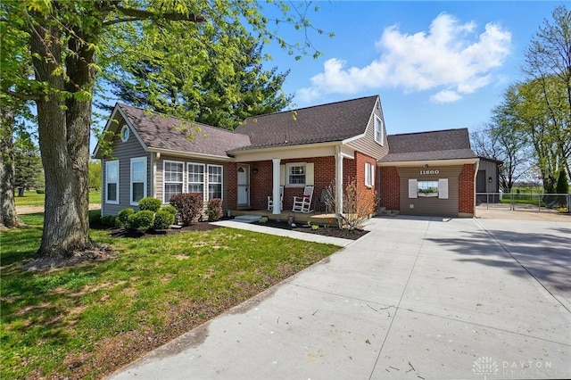 view of front of home with concrete driveway, a front yard, a shingled roof, and brick siding