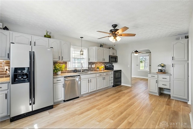 kitchen featuring a sink, white refrigerator with ice dispenser, a ceiling fan, stainless steel dishwasher, and electric range