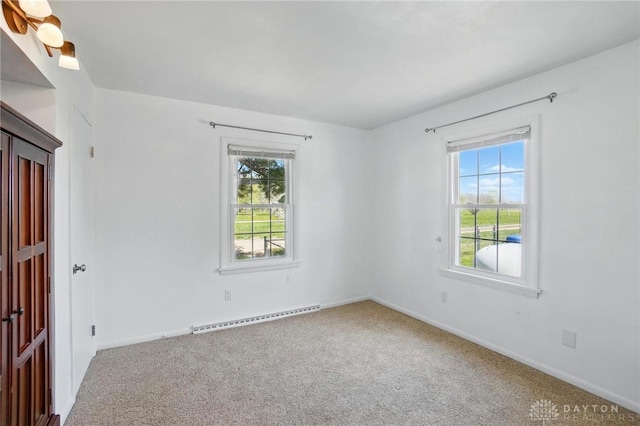 carpeted spare room featuring a baseboard radiator, plenty of natural light, and baseboards