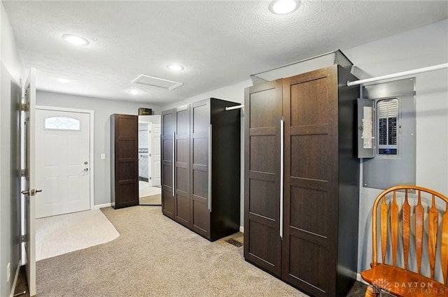 interior space with recessed lighting, a textured ceiling, electric panel, and light colored carpet