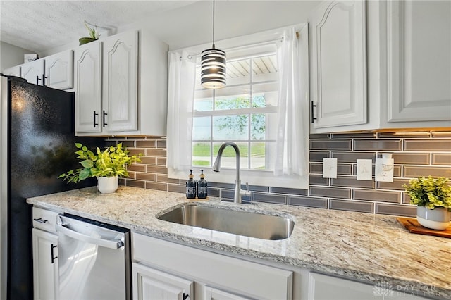 kitchen with light stone counters, white cabinets, a sink, dishwasher, and backsplash