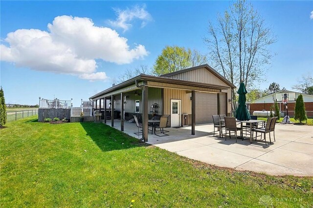 back of property with a patio, fence, a garage, and a lawn
