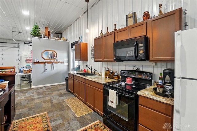 kitchen with a sink, brown cabinetry, black appliances, light stone counters, and pendant lighting