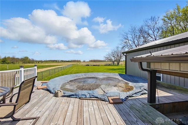 wooden terrace featuring a lawn and a rural view