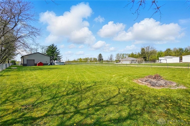 view of yard with an outdoor structure, a garage, and fence
