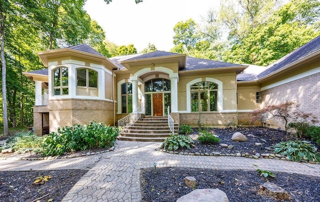 property entrance featuring stucco siding and brick siding