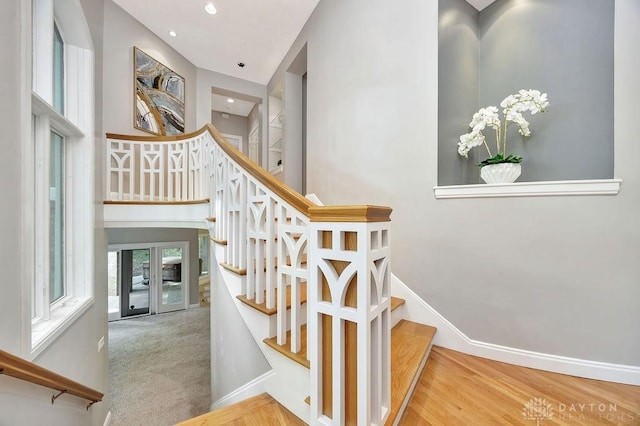 stairway with recessed lighting, wood finished floors, and baseboards