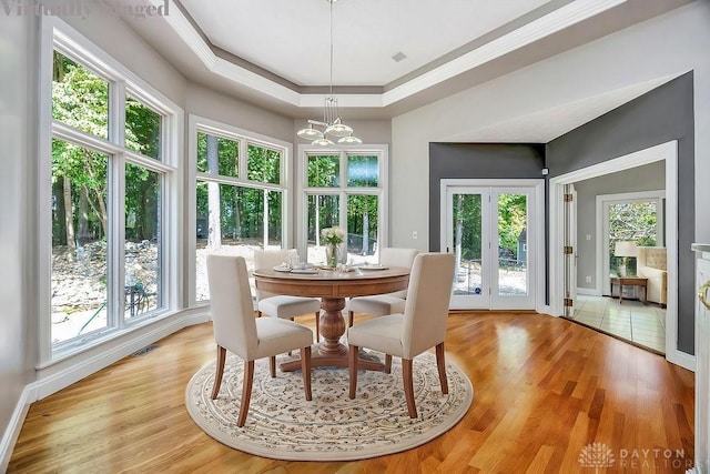 dining area with visible vents, a chandelier, ornamental molding, baseboards, and light wood-type flooring