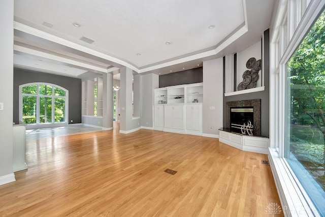 unfurnished living room with a premium fireplace, light wood-style flooring, and baseboards