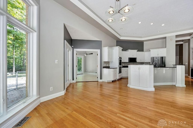 kitchen featuring visible vents, dark countertops, stainless steel appliances, and a wealth of natural light