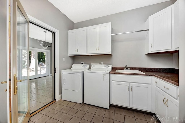 laundry area with washing machine and dryer, light tile patterned flooring, a sink, and cabinet space