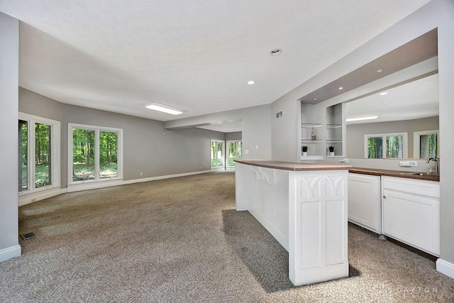 kitchen featuring recessed lighting, carpet floors, white cabinetry, visible vents, and open floor plan
