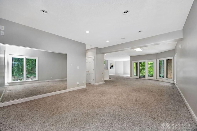 unfurnished living room featuring baseboards, recessed lighting, and carpet floors