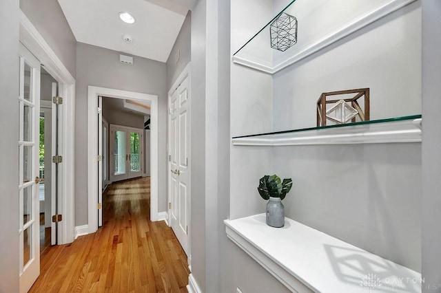 corridor featuring baseboards and light wood finished floors