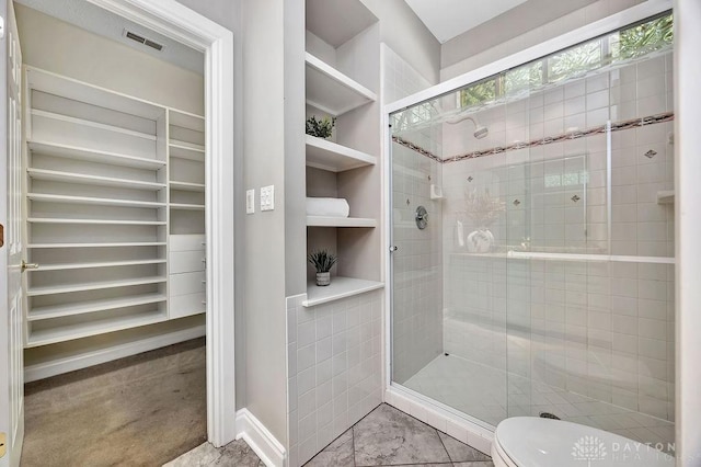 full bath featuring toilet, a stall shower, a walk in closet, and visible vents