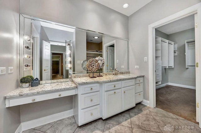bathroom with baseboards, a closet, and vanity