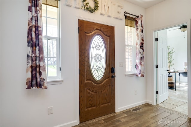 entryway with baseboards, wood finished floors, and visible vents