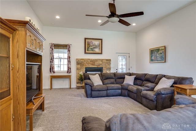 living area featuring carpet floors, baseboards, a stone fireplace, ceiling fan, and recessed lighting