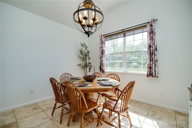 tiled dining area featuring baseboards and a chandelier