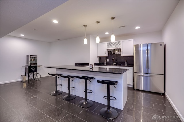 kitchen with visible vents, dark countertops, white cabinets, freestanding refrigerator, and recessed lighting