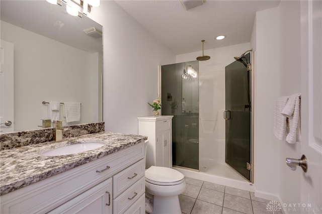 bathroom with vanity, toilet, tile patterned floors, a shower stall, and visible vents