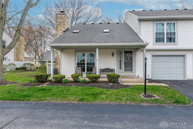 view of front of house with roof with shingles, a chimney, a porch, and an attached garage