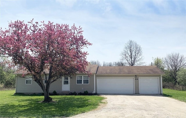 view of front of property with driveway, a front yard, and an attached garage