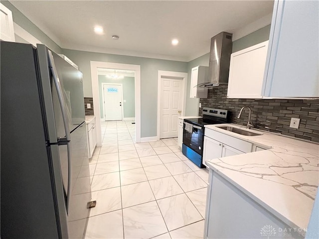 kitchen featuring a sink, tasteful backsplash, wall chimney range hood, white cabinets, and appliances with stainless steel finishes