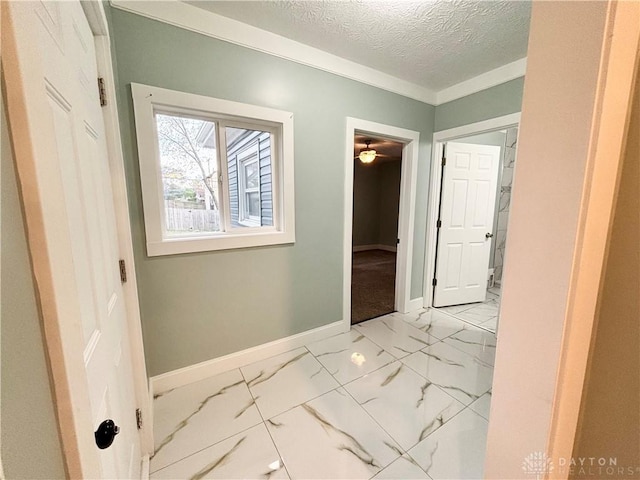 hall featuring baseboards and a textured ceiling