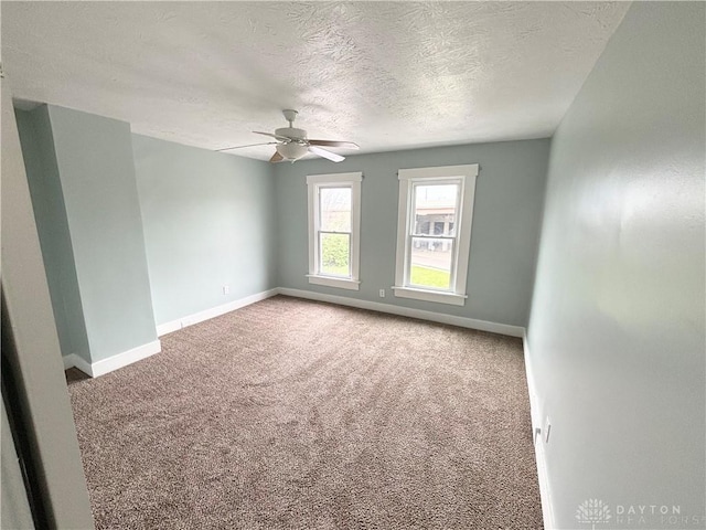 unfurnished room with baseboards, a ceiling fan, a textured ceiling, and carpet flooring