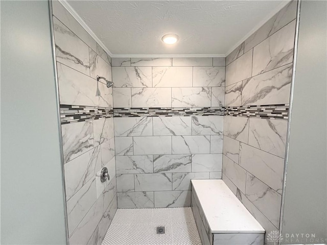 full bath with crown molding and a tile shower
