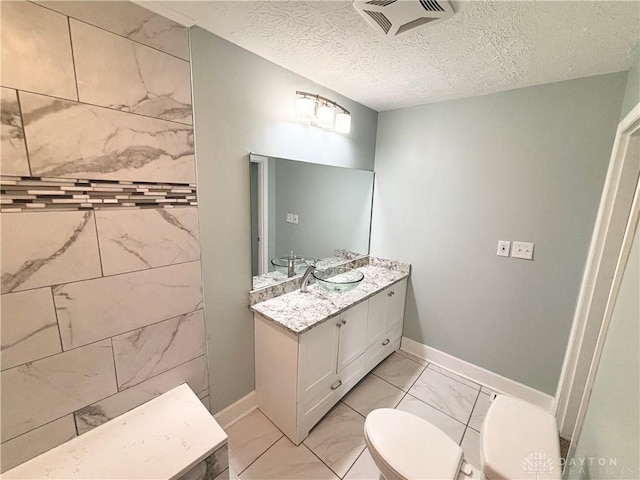 full bathroom with vanity, toilet, marble finish floor, visible vents, and baseboards