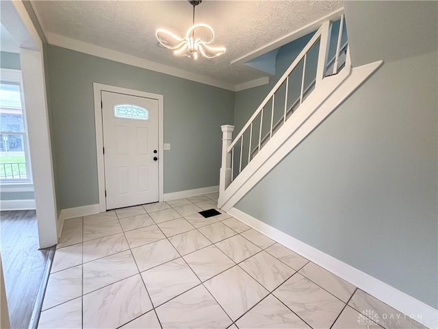 foyer featuring a textured ceiling, stairway, baseboards, an inviting chandelier, and marble finish floor
