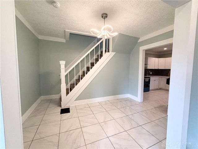 staircase with marble finish floor, a chandelier, a textured ceiling, and baseboards
