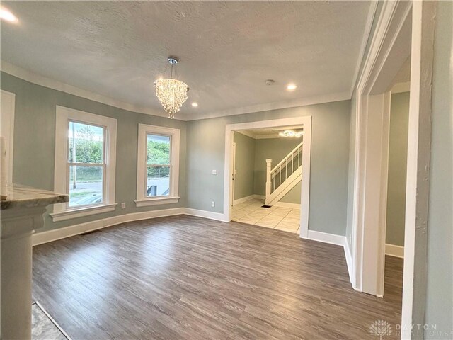 interior space with stairway, wood finished floors, a textured ceiling, and crown molding