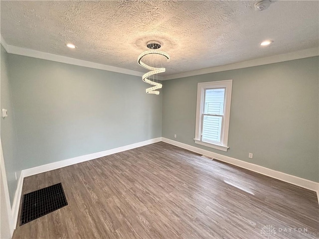 spare room with baseboards, visible vents, dark wood-style flooring, and recessed lighting