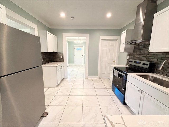 kitchen featuring a sink, stainless steel appliances, tasteful backsplash, marble finish floor, and wall chimney range hood