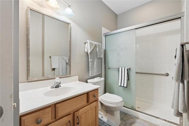 bathroom with toilet, a shower stall, and vanity
