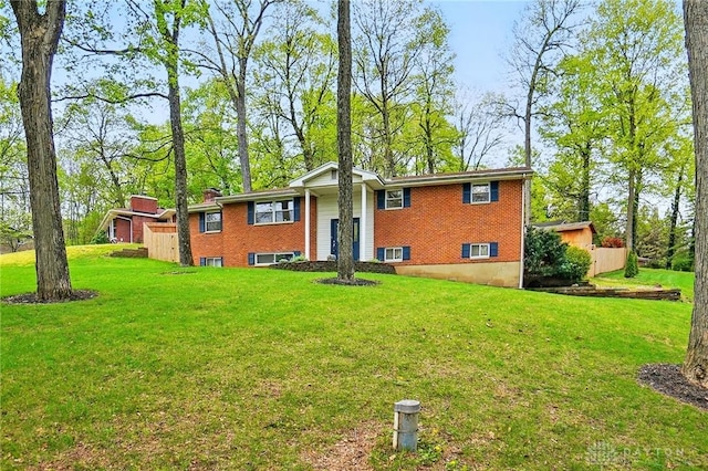 rear view of house featuring a lawn and brick siding
