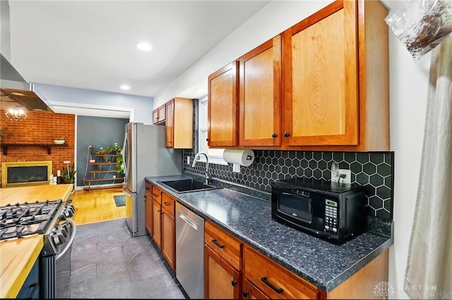 kitchen featuring brown cabinets, a sink, appliances with stainless steel finishes, and tasteful backsplash