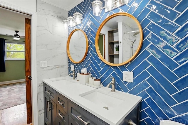 bathroom with tile walls, ceiling fan, vanity, and baseboards