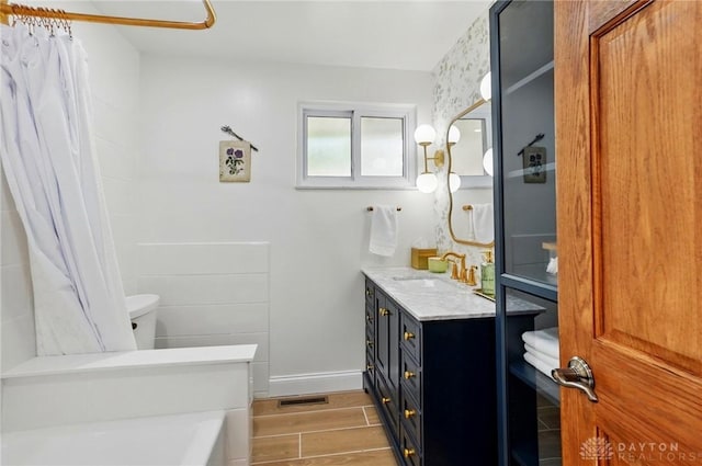 full bath with vanity, curtained shower, toilet, visible vents, and wood finished floors
