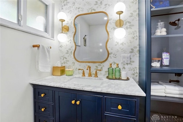 bathroom with wallpapered walls and vanity